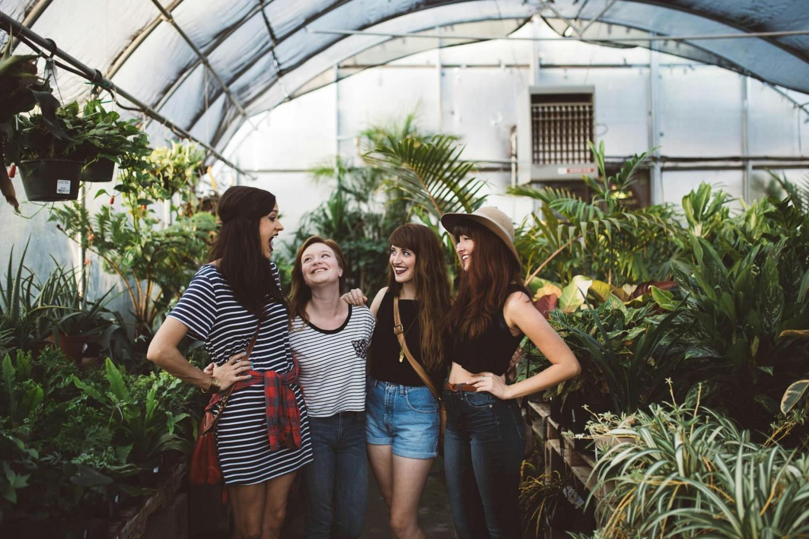 A group of friends hanging out in a greenhouse / polytunnel